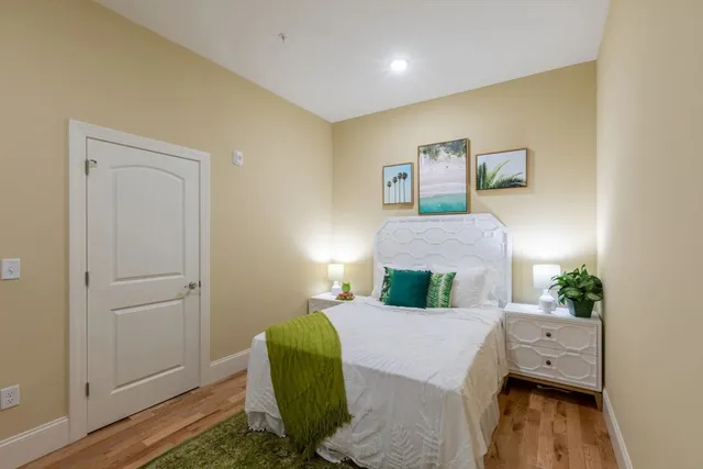 a bedroom with a bed and wooden floor