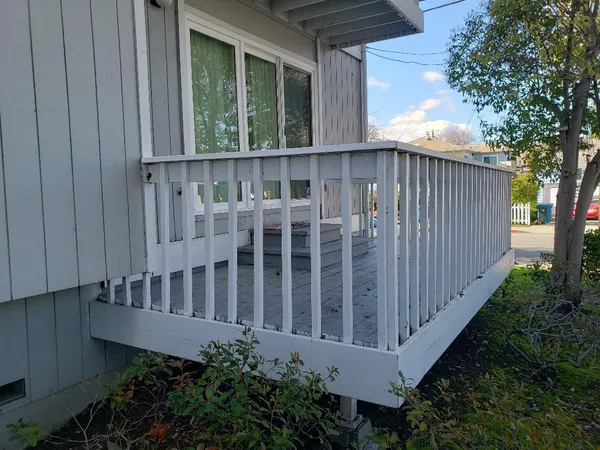 a view of a house with a small yard and wooden fence
