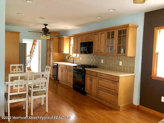 223 Lewis Street Oakhurst, NJ 07755 - Photo 4 of 12 a kitchen with stainless steel appliances kitchen island granite countertop a stove top oven a sink a dining table and chairs
