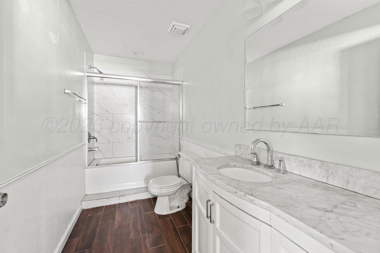 322 Poplar Street Amarillo, TX 79107 - Photo 15 of 42 a bathroom with a granite countertop sink toilet a mirror and shower