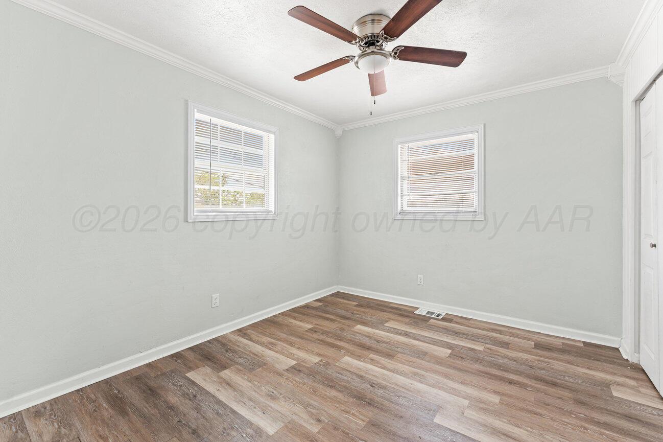 322 Poplar Street Amarillo, TX 79107 - Photo 18 of 42 an empty room with wooden floor ceiling fan and windows
