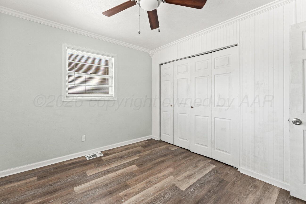 322 Poplar Street Amarillo, TX 79107 - Photo 19 of 42 an empty room with wooden floor cabinet and windows