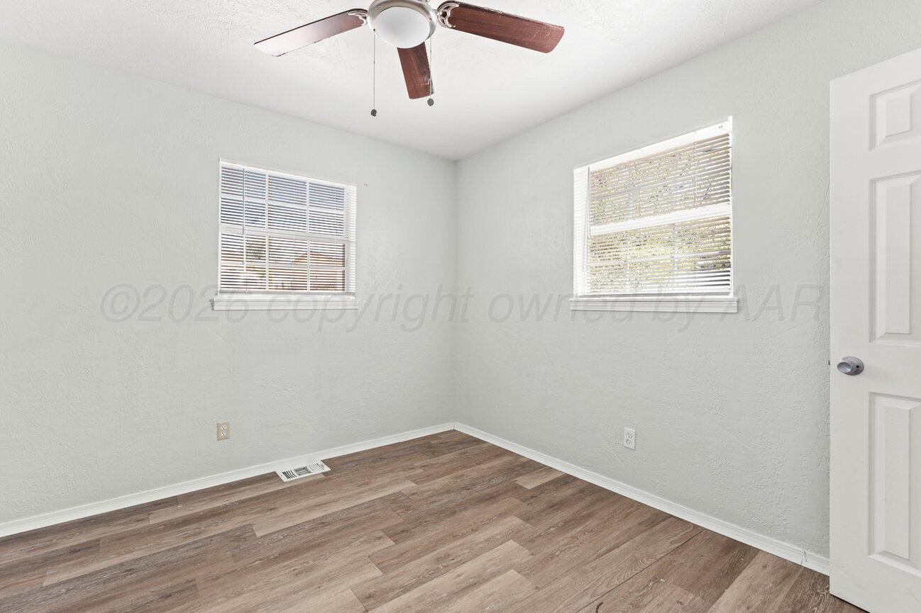 322 Poplar Street Amarillo, TX 79107 - Photo 20 of 42 an empty room with wooden floor chandelier and windows
