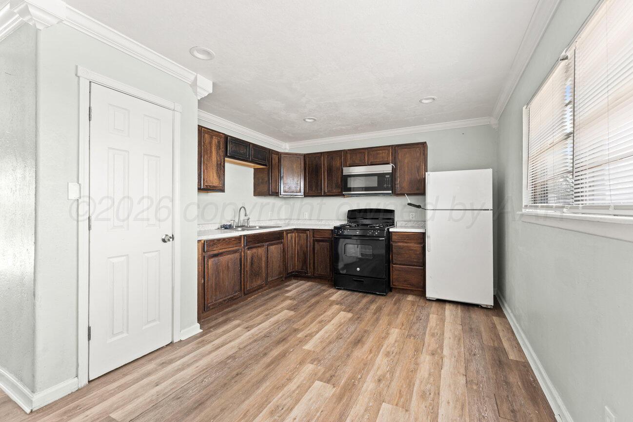322 Poplar Street Amarillo, TX 79107 - Photo 7 of 42 a kitchen with a refrigerator cabinets and wooden floor
