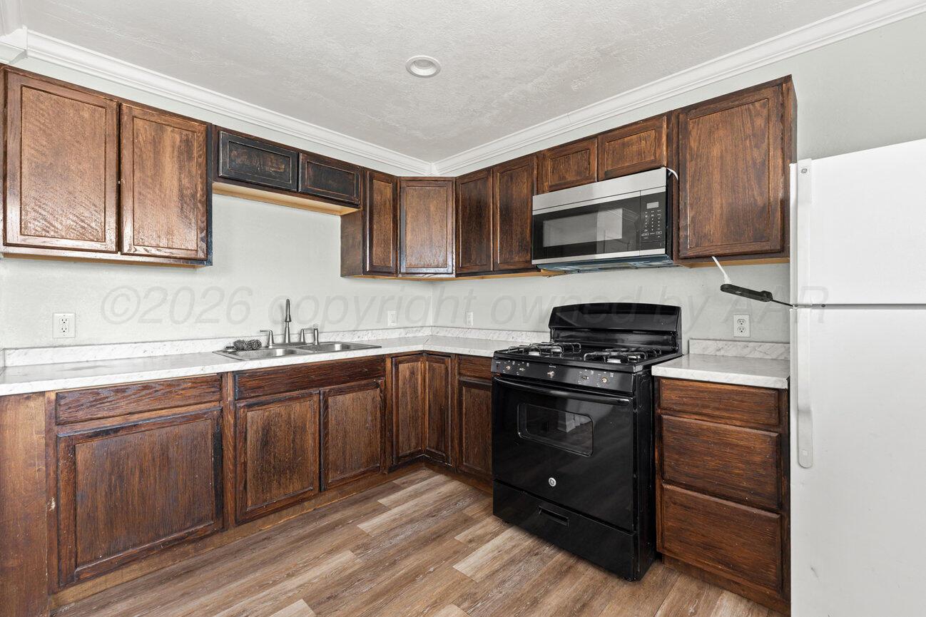 322 Poplar Street Amarillo, TX 79107 - Photo 8 of 42 a kitchen with stainless steel appliances granite countertop a stove microwave and sink
