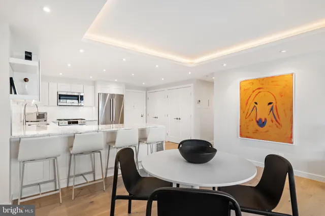 a living room with furniture kitchen view and a flat screen tv