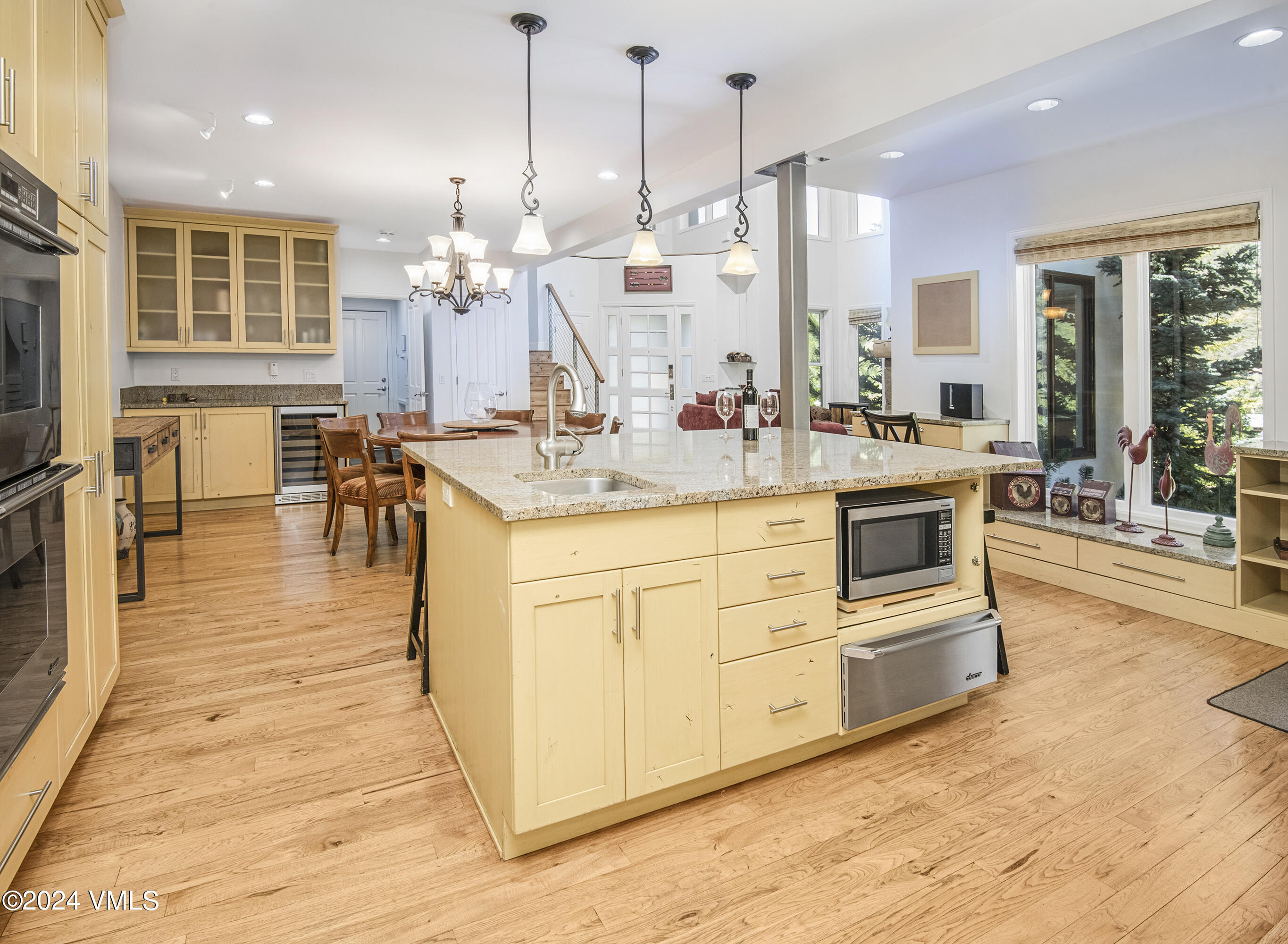 1968 Vermont Road Vail, CO 81657 - Photo 17 of 69 a large kitchen with kitchen island a stove a sink a dining table and chairs with wooden floor