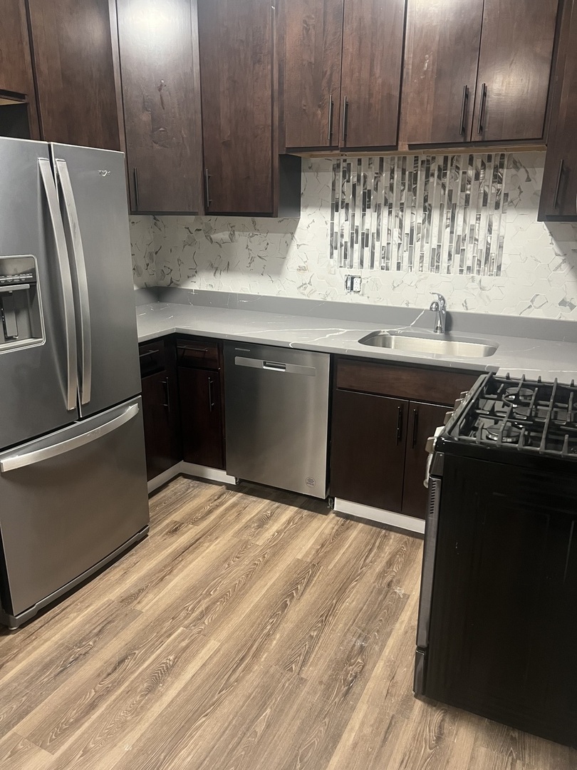 1434 South St Louis Avenue, Unit 1 Chicago, IL 60623 - Photo 3 of 9 a kitchen with granite countertop a refrigerator and a stove