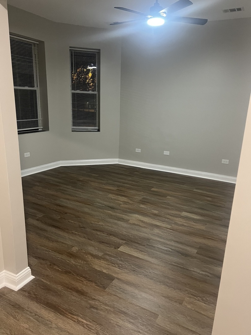 1434 South St Louis Avenue, Unit 1 Chicago, IL 60623 - Photo 4 of 9 a view of an empty room with wooden floor and windows