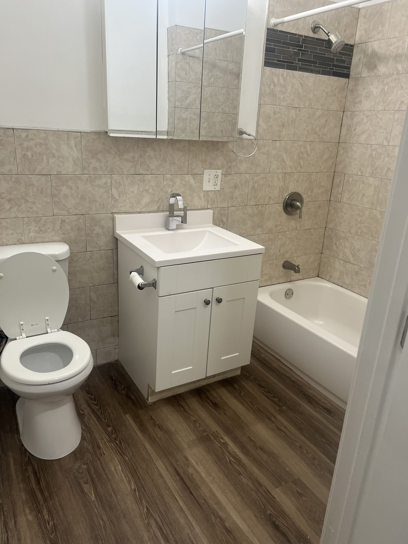 1434 South St Louis Avenue, Unit 1 Chicago, IL 60623 - Photo 5 of 9 a bathroom with a sink toilet and vanity