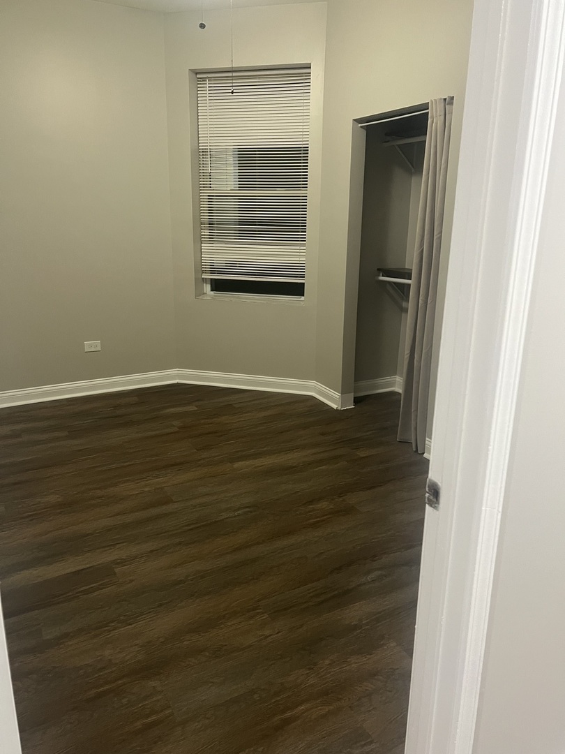1434 South St Louis Avenue, Unit 1 Chicago, IL 60623 - Photo 7 of 9 an empty room with wooden floor closet and windows