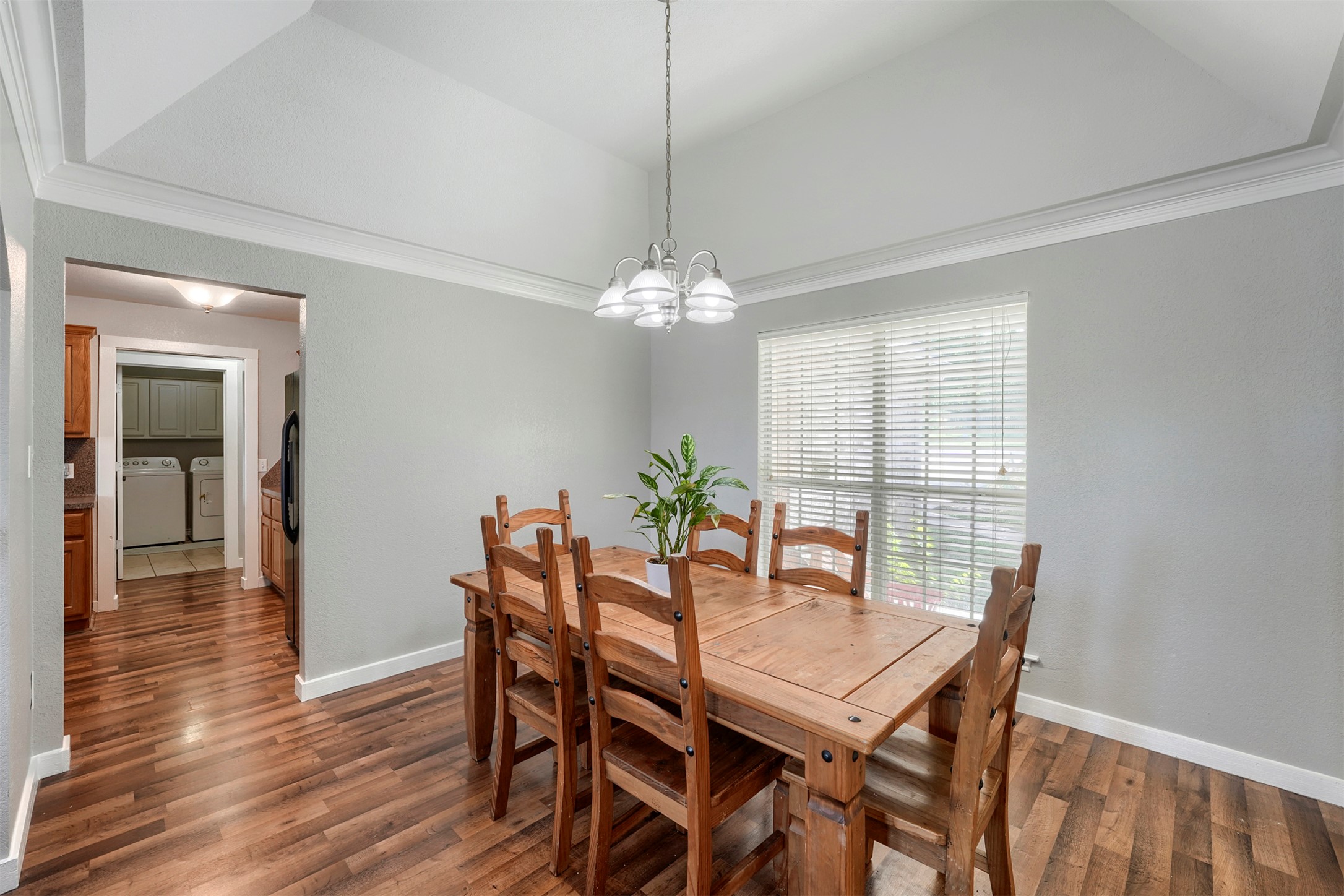 1105 2nd Street Jarrell, TX 76537 - Photo 7 of 27 A charming dining space with vaulted ceilings and rich wood flooring, perfect for gatherings.