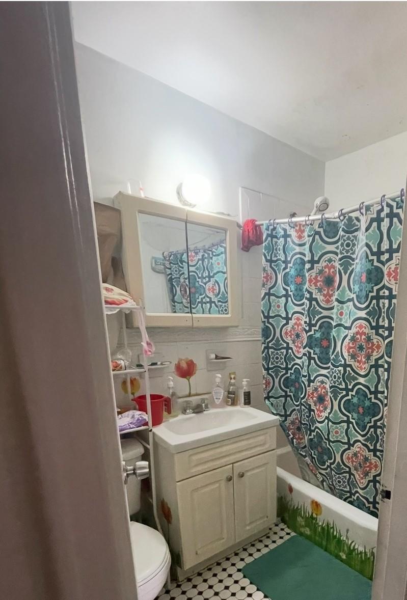 131-11 Kew Gardens Road, Unit 6N Queens, NY 11418 - Photo 9 of 9 Bathroom with vanity, tile walls, toilet, tile patterned floors, and shower / bath combo