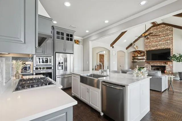 a kitchen with stainless steel appliances granite countertop a sink stove and refrigerator