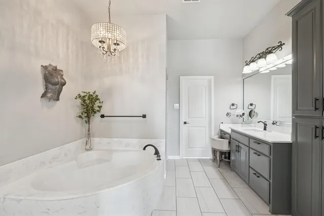 a spacious bathroom with a granite countertop sink a mirror and a bathtub
