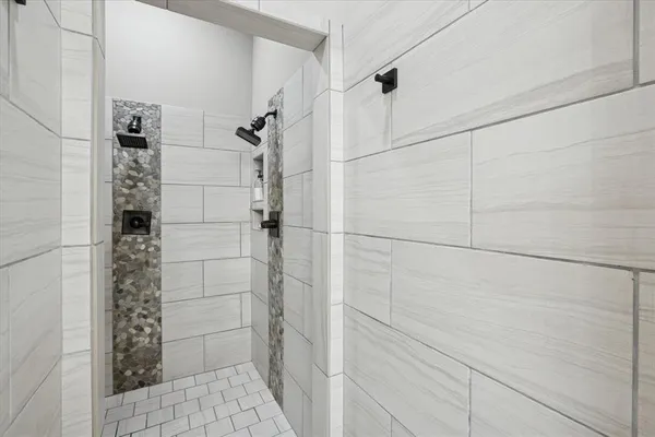 a spacious bedroom with a bed a chandelier and a large window