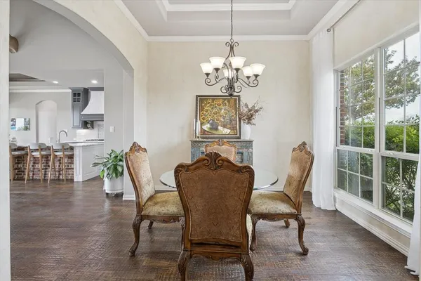a dining room with furniture a chandelier and wooden floor