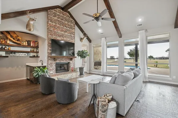 a living room with furniture a fireplace and a floor to ceiling window
