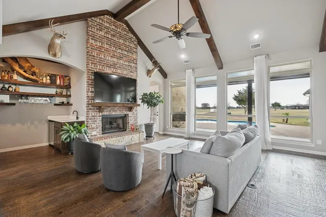 a living room with furniture a fireplace and a floor to ceiling window