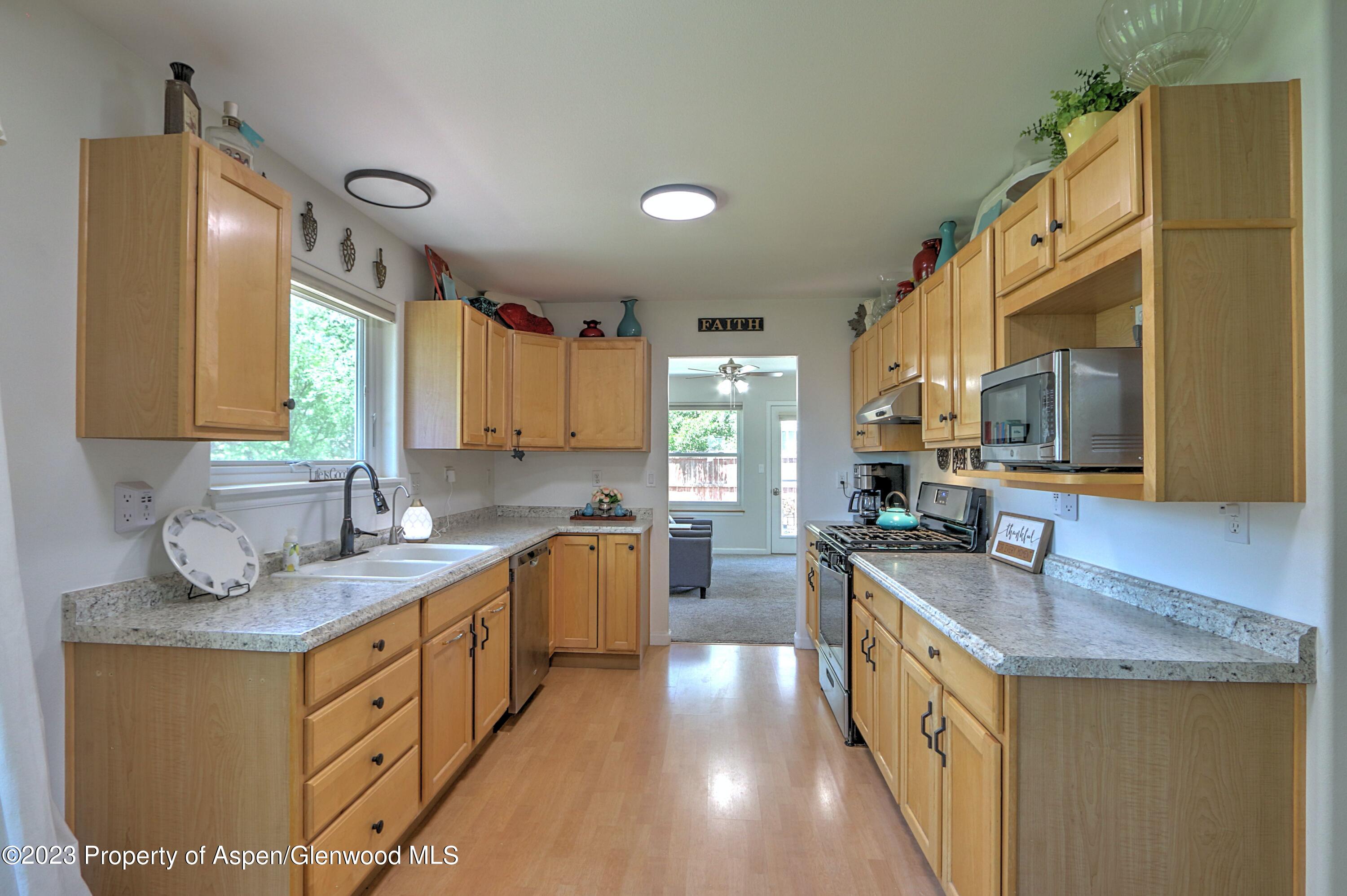 1527 Graham Court Rifle, CO 81650 - Photo 11 of 32 a kitchen with stainless steel appliances granite countertop a sink stove and refrigerator