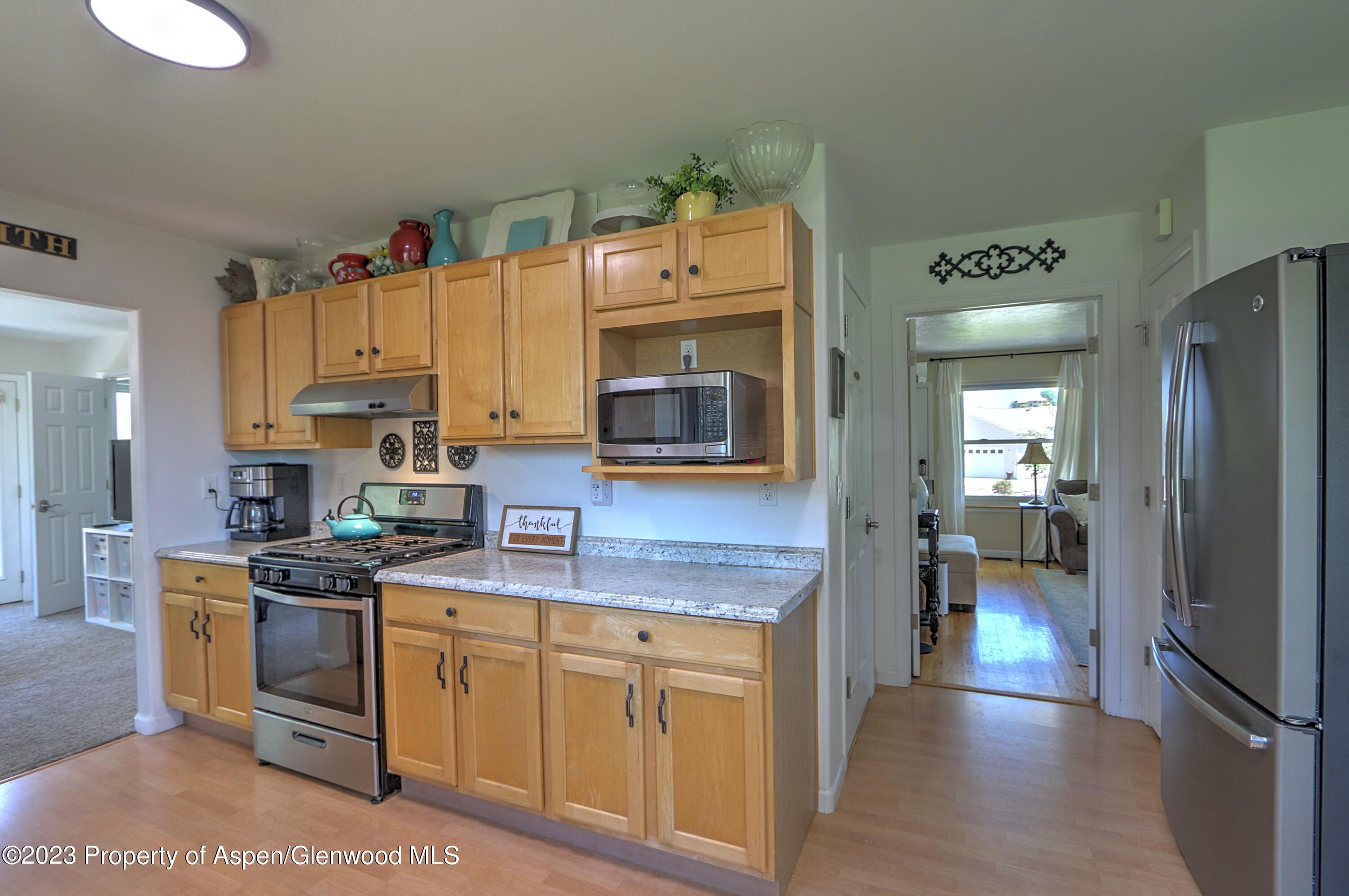 1527 Graham Court Rifle, CO 81650 - Photo 12 of 32 a kitchen with cabinets wooden floor and stainless steel appliances