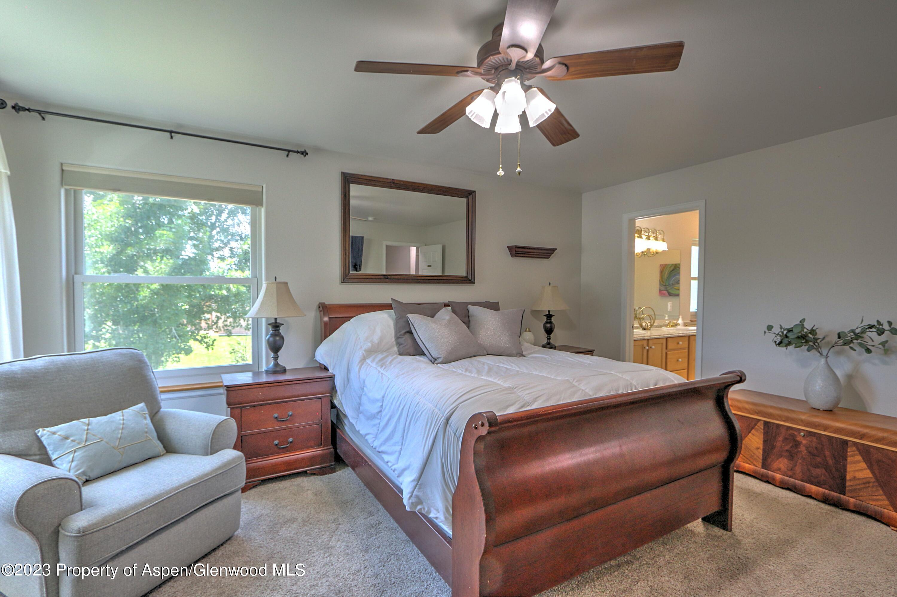 1527 Graham Court Rifle, CO 81650 - Photo 19 of 32 a bedroom with a large bed couch and windows