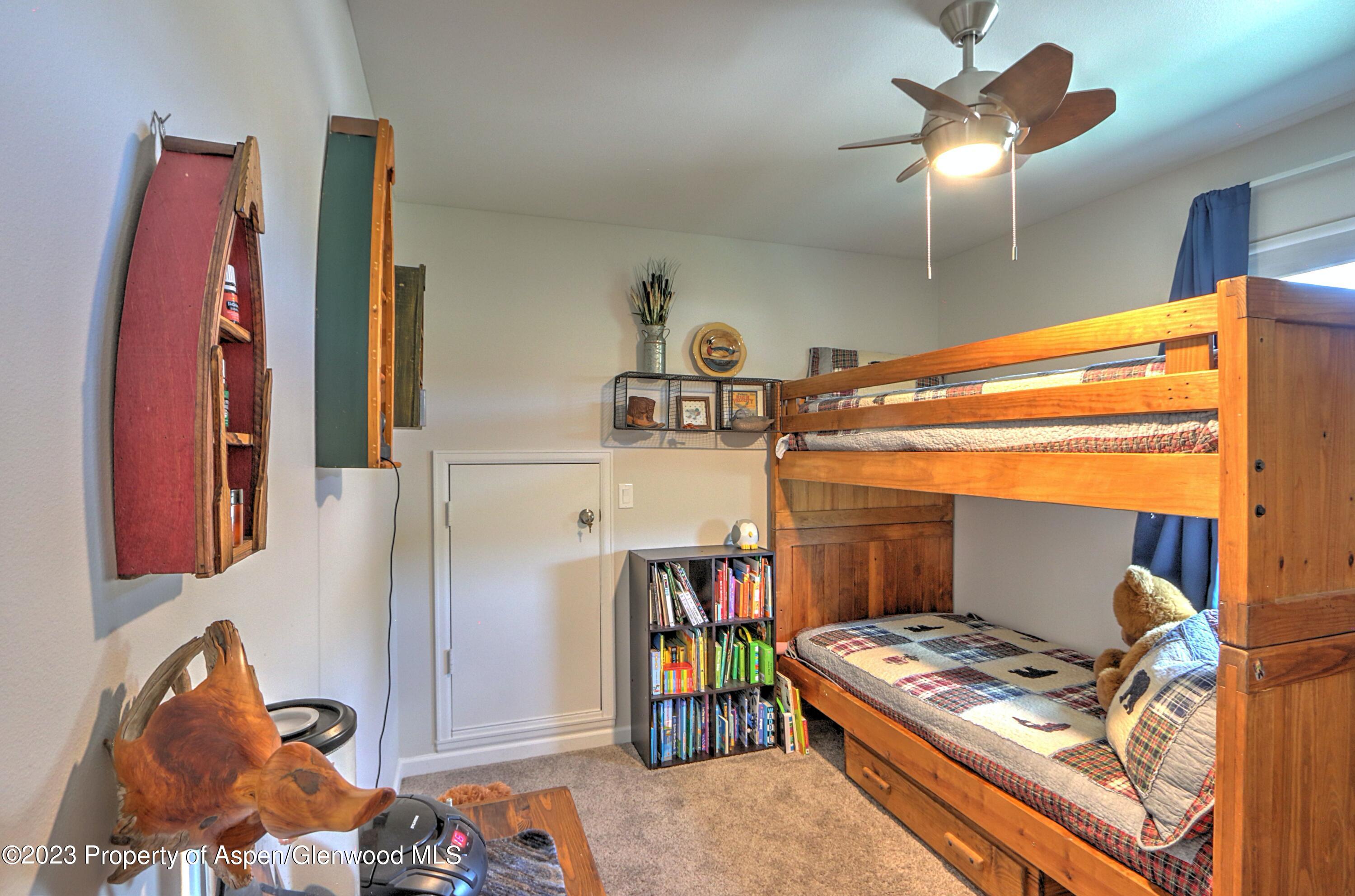 1527 Graham Court Rifle, CO 81650 - Photo 22 of 32 a bedroom with a bed and a chandelier