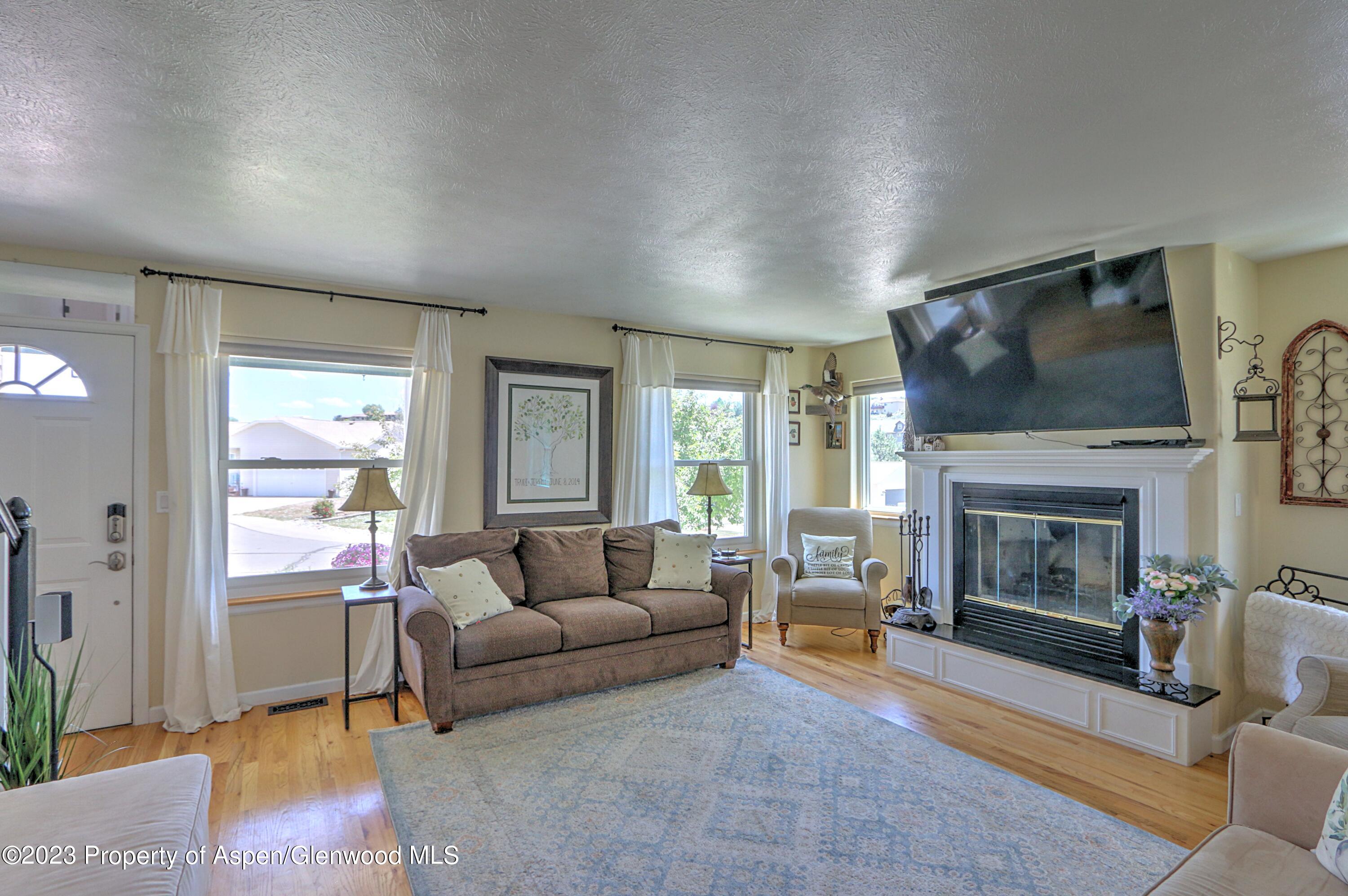 1527 Graham Court Rifle, CO 81650 - Photo 6 of 32 a living room with furniture a flat screen tv and a fireplace