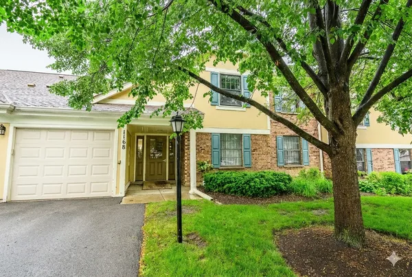 a front view of a house with a garden and plants