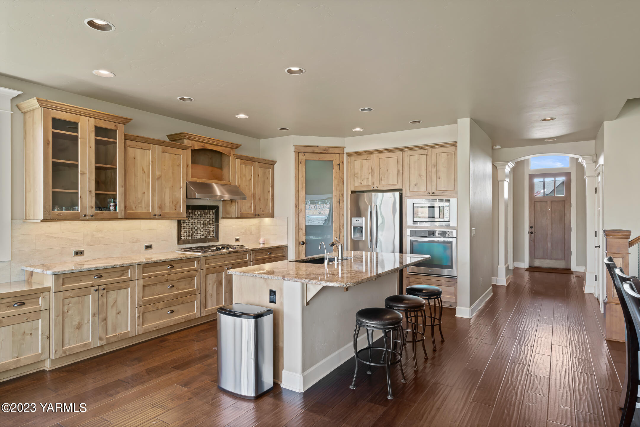 2978 Crosswater Loop Richland, WA 99354 - Photo 11 of 34 a kitchen with stainless steel appliances a dining table chairs sink and wooden floor
