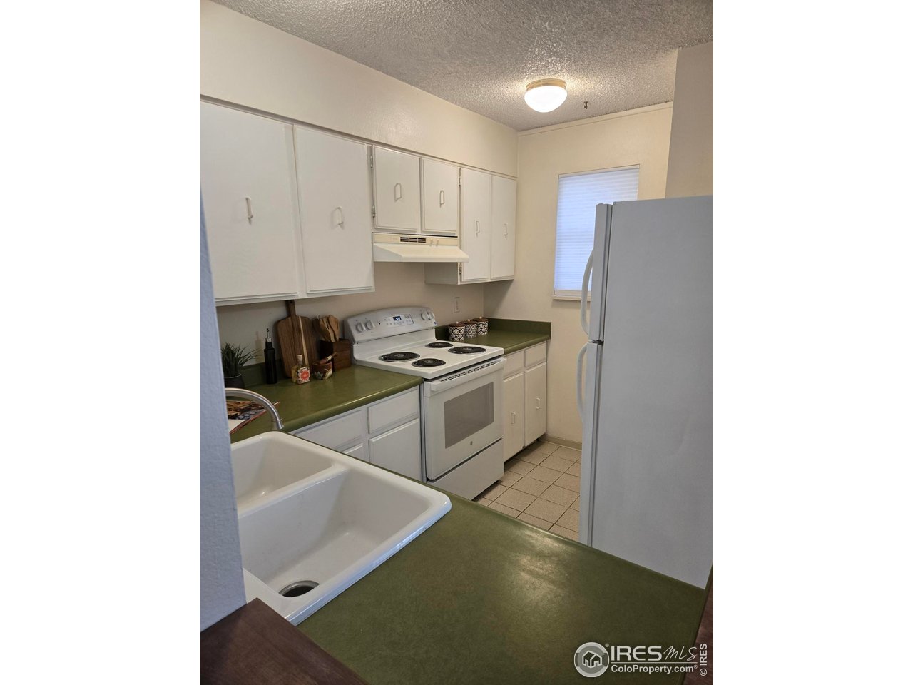 1705 Heatheridge Road, Unit E101 Fort Collins, CO 80526 - Photo 10 of 23 a kitchen with cabinets and white appliances