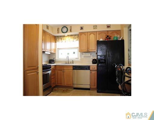 17 Monaghan Road Edison, NJ 08817 - Photo 4 of 25 a kitchen with a refrigerator and a window
