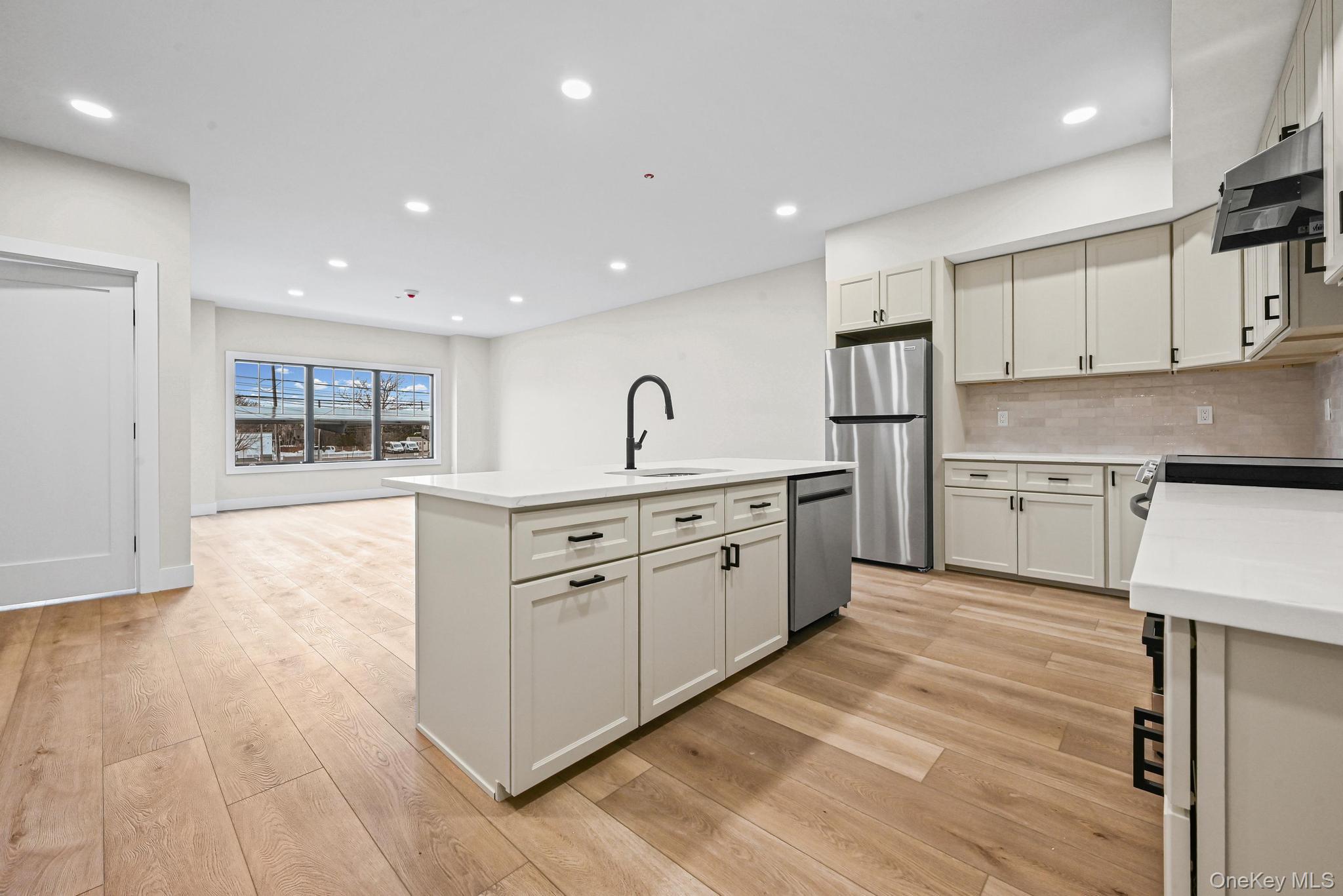 80 Division Street, Unit 2G Patchogue, NY 11772 - Photo 2 of 9 a kitchen with stainless steel appliances granite countertop a stove a sink and a refrigerator