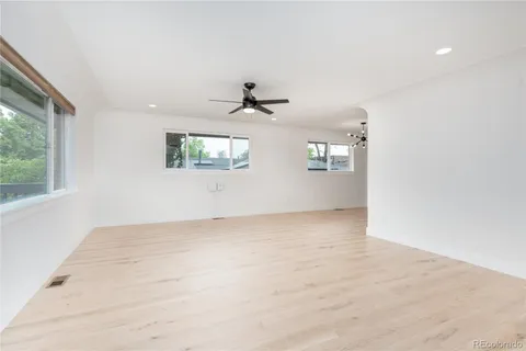 an empty room with windows and ceiling fan