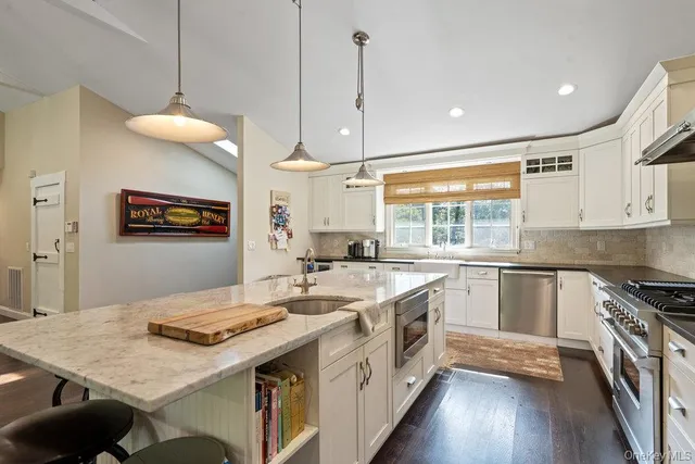 a kitchen with a stove window and wooden floor
