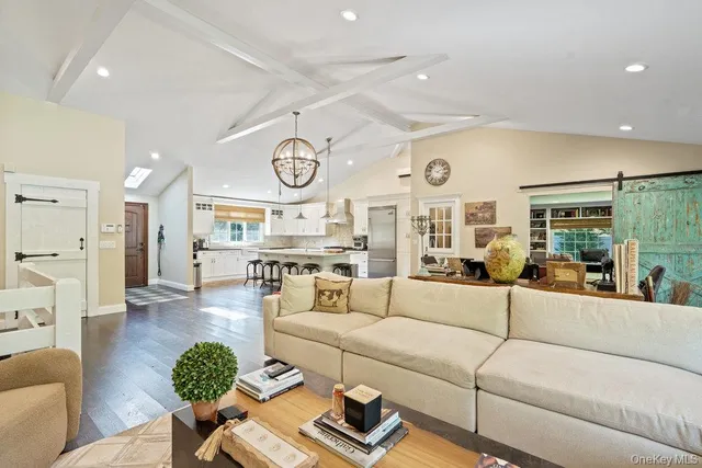 a living room with furniture kitchen view and a large window