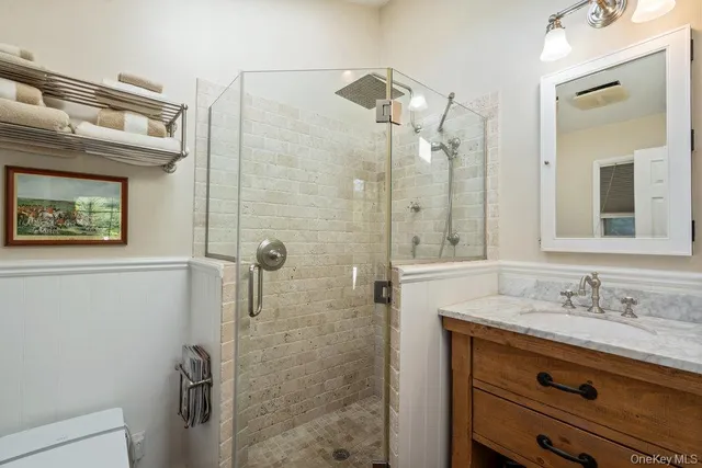 a bathroom with a granite countertop shower sink vanity and mirror