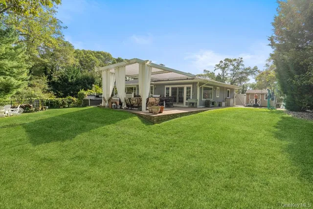 a view of a house with a big yard and large trees