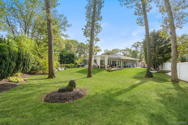 a view of a house with backyard and trees