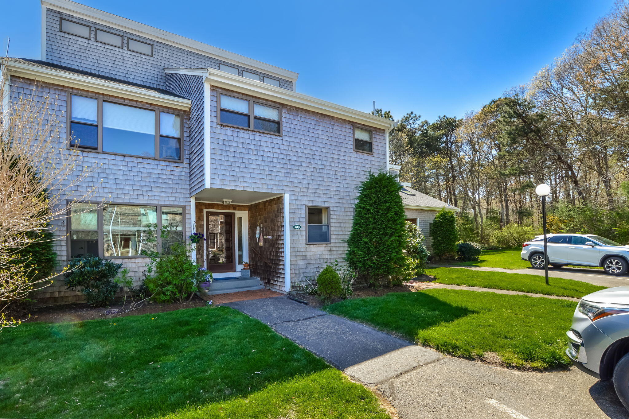 4 Riverview Avenue, Unit G Mashpee, MA 02649 - Photo 2 of 39 a view of a house with a yard and plants