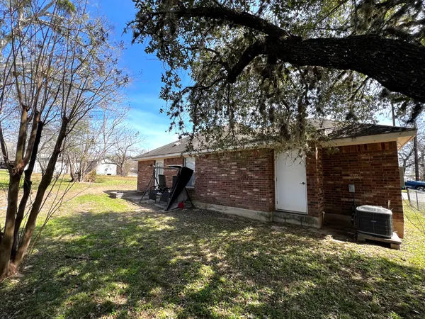 a view of a house with a yard tree and a fire pit