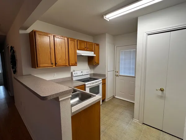 a kitchen with a refrigerator sink and cabinets