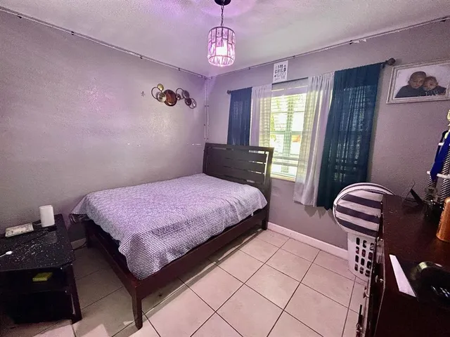 a bedroom with a bed and painting on the wall