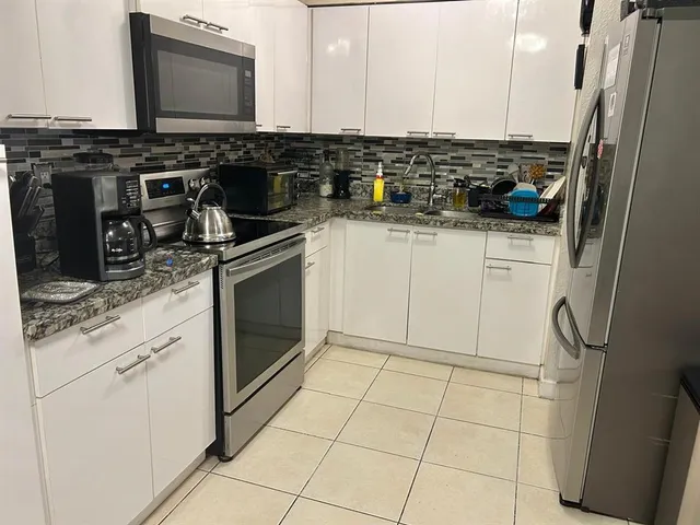 a kitchen with a sink a stove and cabinets