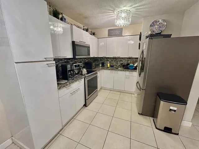 a kitchen with stainless steel appliances a refrigerator sink and microwave