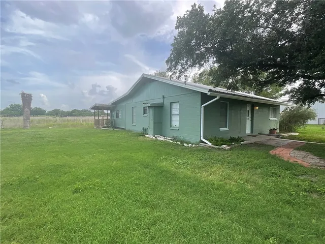 a backyard of a house with lots of green space and garden