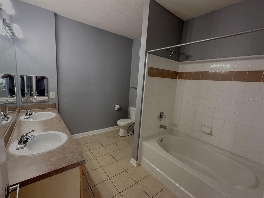 204 Terrace Ridge Circle, Unit 204 Davenport, FL 33896 - Photo 11 of 17 a bathroom with a sink a toilet and shower
