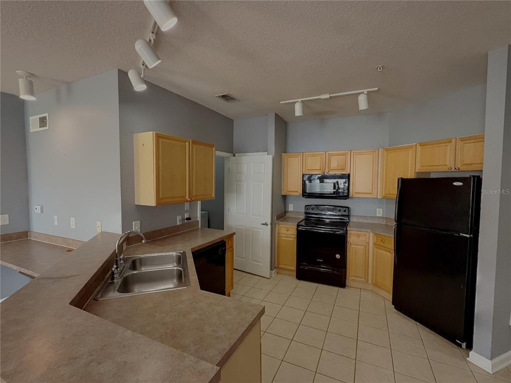 204 Terrace Ridge Circle, Unit 204 Davenport, FL 33896 - Photo 3 of 17 a kitchen with a refrigerator and a sink