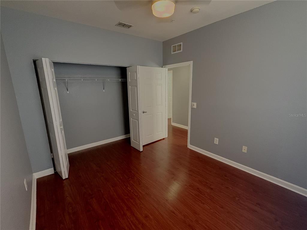 204 Terrace Ridge Circle, Unit 204 Davenport, FL 33896 - Photo 9 of 17 an empty room with wooden floor and closet