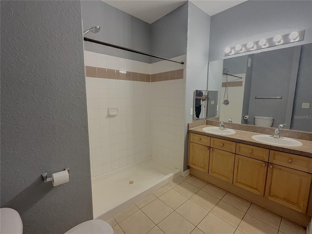204 Terrace Ridge Circle, Unit 204 Davenport, FL 33896 - Photo 10 of 17 a bathroom with a double vanity sink toilet and shower